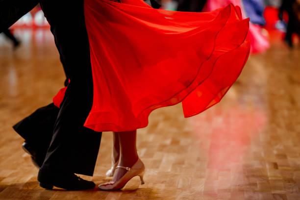 Danseurs de salon, robe rouge en mouvement sur le parquet